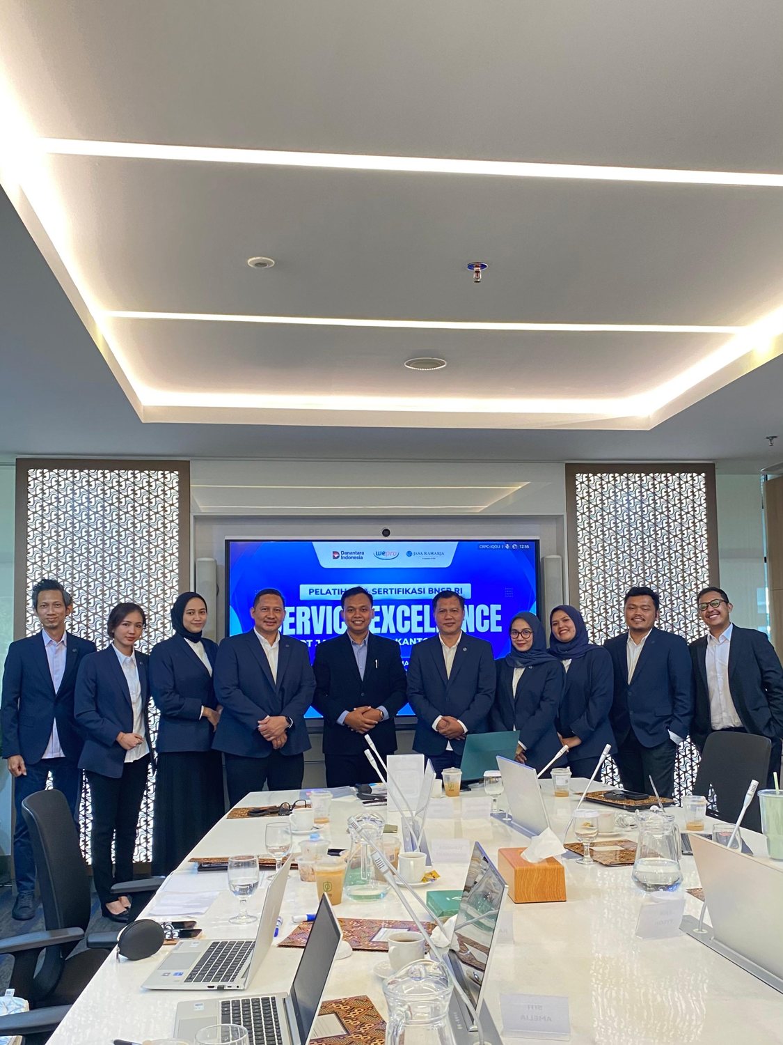 A diverse group of business professionals attending a presentation in a modern conference room.